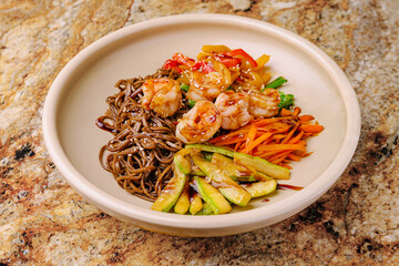 Delicious shrimp and vegetable stir fry served over soba noodles in a bowl