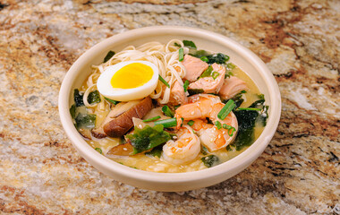 Delicious seafood ramen served in a warm bowl on a granite surface