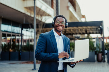 African american man working remotely with laptop outdoors