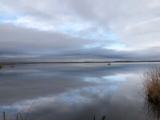 A quiet evening on a lake, low clouds reflected in the smooth water
