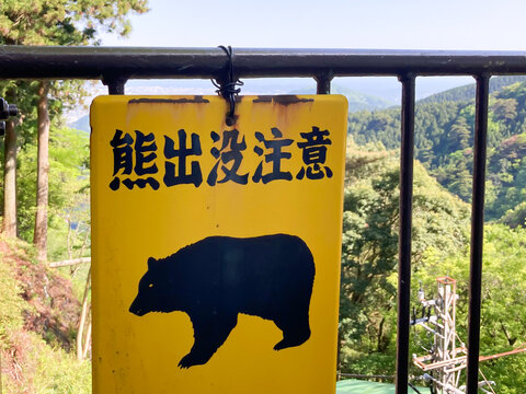 山のフェンスに掲示された熊出没注意の看板