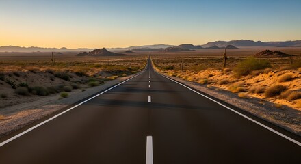Photo of the highway stretching straight across the desert with a background of desert hills, kaptuus trees and bushes