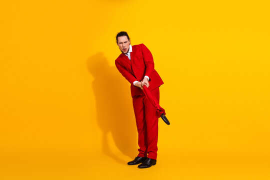 Funny bold man in red suit performs quirky pose against bright yellow backdrop for fashion humor and promo imagery