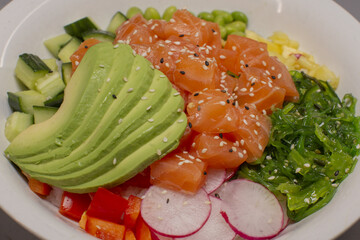Vibrant poke bowl, Fresh salmon and avocado dish, Casual healthy salmon avocado poke bowl, Colorful salmon avocado poke bowl with seaweed and vegetables