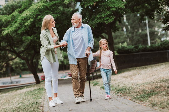 funny heartwarming stroll in the park with grandpa daughter and little girl sharing smiles and love