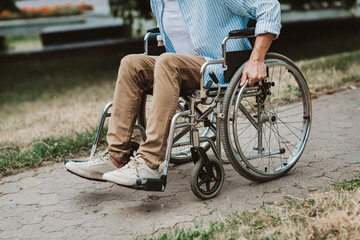 Obraz premium Cheerful man in a wheelchair enjoys park stroll with family bond and recovery spirit on a sunny day