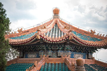 Naklejka premium Ancient building details from Beijing, China's Summer Palace. Close up view showcasing architectural designs. Ornate structure under a cloudy sky.