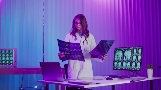 Female Doctor in White Coat Comparing Multiple Brain Scans Under Neon Lighting. Concept of Scientific Research, Neurology, and Breakthrough Innovations in Modern Healthcare and Diagnostics.