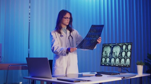 Doctor in White Coat Carefully Examines Brain MRI Scan Under Blue Neon Light. Concept of Neurology, Scientific Discovery, and Cutting-Edge Research in Modern Healthcare and Diagnostics.