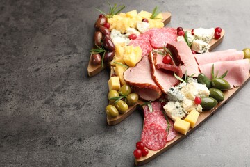 Delicious Christmas Charcuterie board with snacks on grey textured table. Space for text