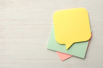 Different blank paper notes on white wooden table, top view. Mockup for design