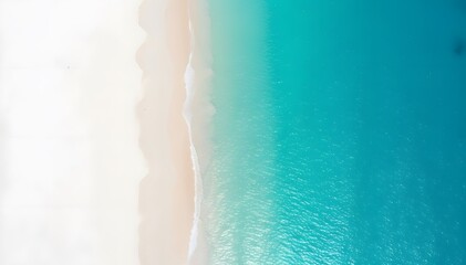 Drone photo of a view of a white beach with a light blue sea, as if divided into two sides, the sea side and the beach side.