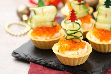 Tasty tartlets on grey textured table, closeup. Christmas appetizer