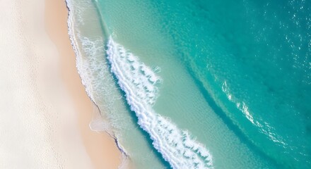 Drone photo of a view of a white beach with a light blue sea, as if divided into two sides, the sea side and the beach side.