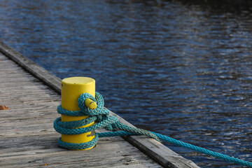 A bollard is a short, strong vertical post used on a pier to secure ropes. Marine, ship, and harbor background © Alexander