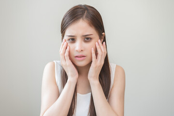 Fototapeta premium Bored, insomnia asian young woman, girl looking at camera, hand touching under eyes with problem of black circles or panda puffy, swollen and wrinkle on face. Sleepless, sleepy healthcare person.