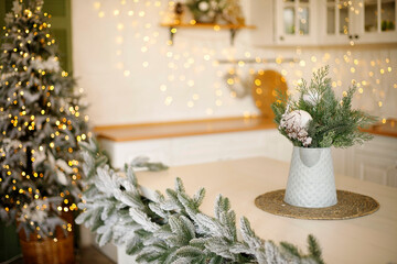 Festive kitchen interior featuring a beautifully arranged table with a decorative vase, surrounded by holiday decorations and twinkling lights, creating a warm and inviting atmosphere