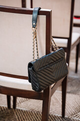 Fototapeta premium elegant purse on cozy chair, luxury designer handbag beside plush carpet in sophisticated room