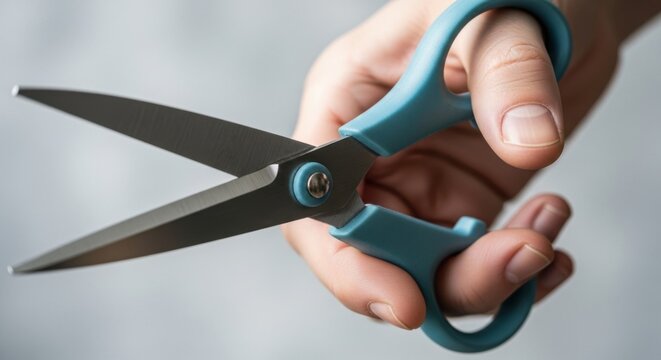 Hand holding blue scissors
