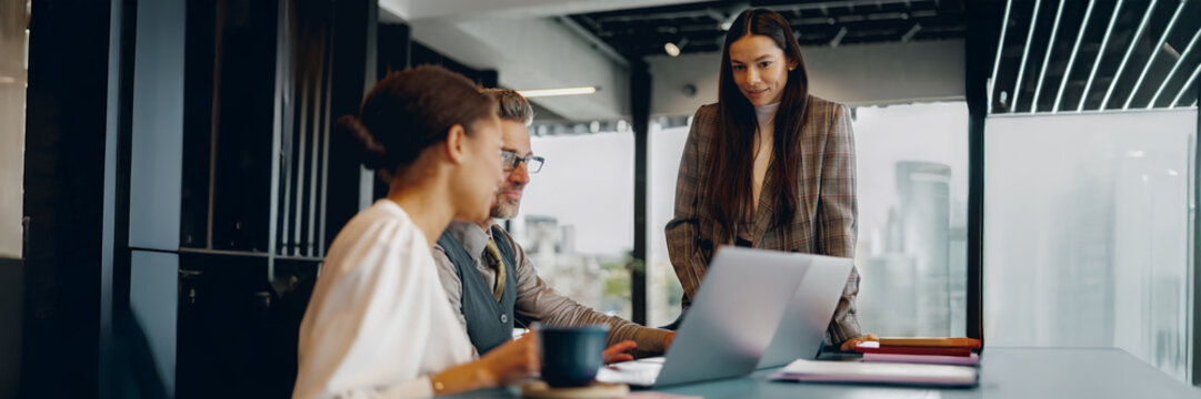 During a meeting in a modern office, team members actively engage in insightful discussion and collaboration - Powered by Adobe