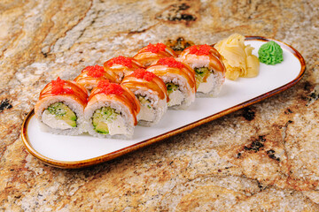 Fresh sushi rolls with avocado and salmon on a marble table