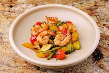 Shrimp stir-fry with colorful vegetables on a granite countertop