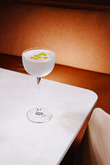 Refreshing cocktail served in a stylish glass on a white table