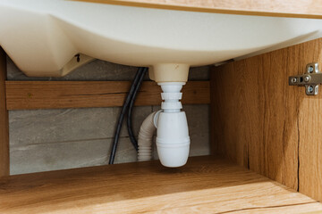 The UnderSink Plumbing System includes a durable White PVC PTrap and a stylish Wooden Cabinet,...