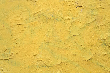 Old yellow grunge wall with cracked paint. High resolution vintage background.