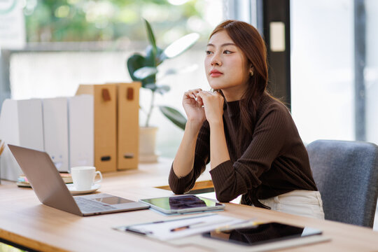 Concerned puzzled asian freelance worker woman looking at laptop with confused hand gesture. Frustrated worried computer user getting bad news, job technology failure, feeling shock, stress.
