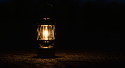 Vintage lantern glows warmly on textured ground creating a cozy, inviting atmosphere for adventure and storytelling