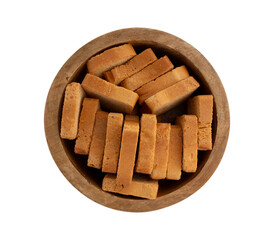 whole wheat mini toasts, toasted slices of bread or rusks in wooden bowl isolated on white background, top view