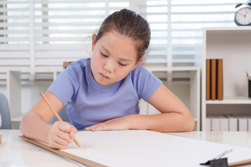 Naklejka premium Caucasian preteen girl elementary student sitting classroom art table holding pencil carefully drawing sketch on large paper expressing concentration dedication academic creativity learning process
