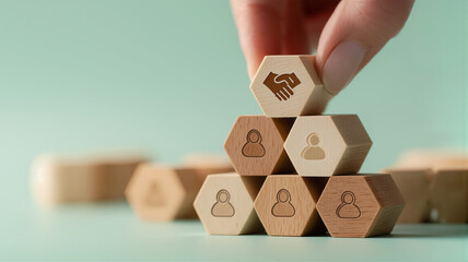 Hand placing handshake block on business team collaboration pyramid