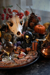 wiccan altar with wheel of the year on dark table close up. animal skull, witch amulets, crystals, magical things. witchcraft, black magic. esoteric ritual for Samhain holiday. autumn season.