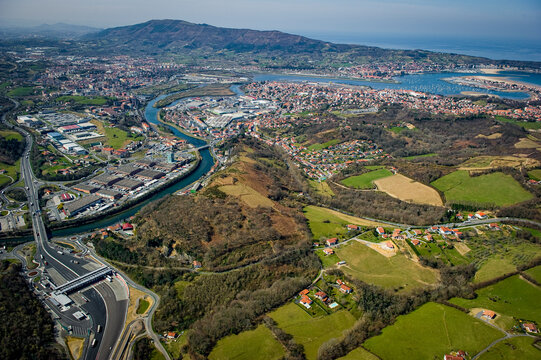 The aerial view captures the beautiful landscapes around Peage Biriatou and Hendaye, featuring lush greenery, winding rivers, and a coastal town under a clear blue sky. - Powered by Adobe