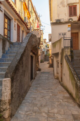Narrow stone pathway in picturesque mediterranean village street scene. Baska, Krk island, Croatia