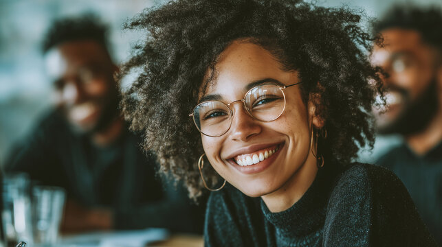 Group of young Black professionals smiling and laughing during meeting, candid lifestyle tone, cinematic lighting