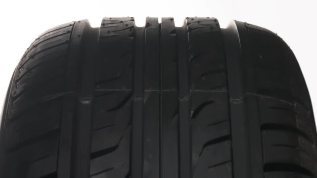 Seasonal Tire Change Symbol. The concept of seasonal tire replacement. Close-up new car wheel slowly spinning. A cold weather warning sign appears on the tread side of the wheel