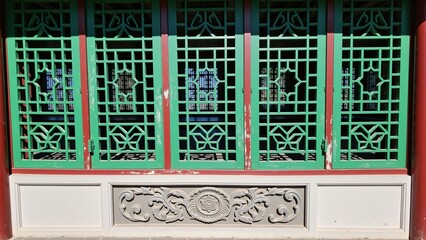 Chinese style ancient building with green windows and red columns