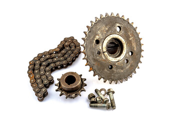 An old motorcycle sprocket and chain, thickly coated in black oil and grease, on a white background. Perfect for motorcycle repair and maintenance topics.