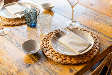 Set table with plates, glasses and cutlery in luxury modern wooden restaurant
