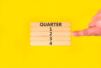 2nd second quarter 2 symbol. Concept word Quarter 2 on beautiful wooden sticks. Beautiful yellow background. Businessman's hand. Business, happy 2nd second quarter 2 Q2 concept. Copy space.