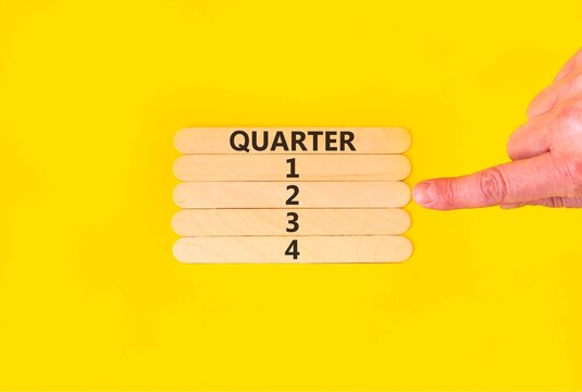 2nd second quarter 2 symbol. Concept word Quarter 2 on beautiful wooden sticks. Beautiful yellow background. Businessman's hand. Business, happy 2nd second quarter 2 Q2 concept. Copy space.