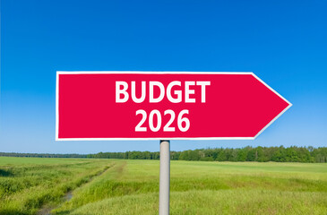Budget 2026 symbol. Concept words Budget 2026 on beautiful red road sign. Beautiful green grass field forest and blue sky background. Business and budget 2026 concept. Copy space.