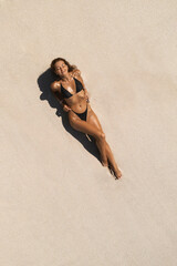 Aerial View Of Woman In Black Bikini Relaxing On Sandy Beach 