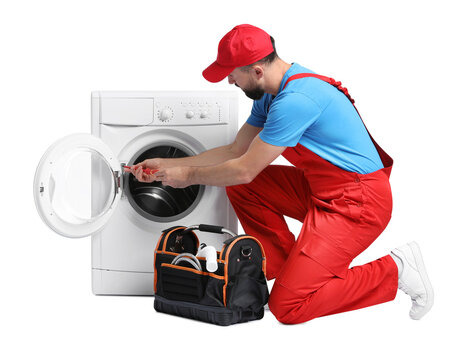 Professional repairman with tools fixing broken washing machine on white background