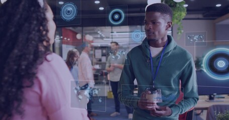 Holding travel mug, Black man in green hoodie viewing digital overlays in office, copy space