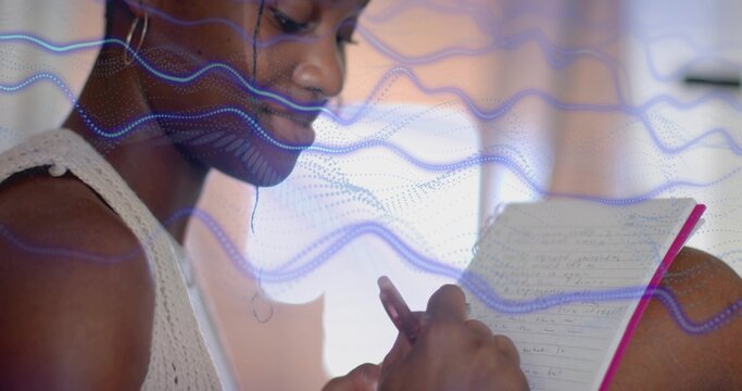 Writing Black woman in sleeveless top at desk, holding pen with pink notebook and blue overlay - Powered by Adobe