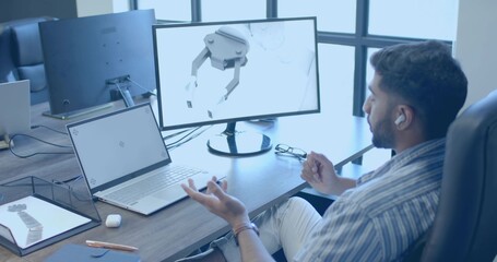 Designer modeling robotic gripper on monitor in modern tech office, with laptop tablet, copy space